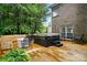 Relaxing hot tub on a wooden deck with mature trees in the background, perfect for outdoor enjoyment at 6324 Old Fox Hunt Ln, Mint Hill, NC 28227