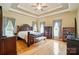 Elegant main bedroom with tray ceiling, hardwood floors, and ample natural light at 6324 Old Fox Hunt Ln, Mint Hill, NC 28227