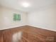 Empty bedroom showcasing hardwood floors and natural light from a large window at 643 Baron Rd # 8, Waxhaw, NC 28173
