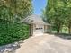 View of the garage with stone veneer and a large driveway nestled between lush trees at 643 Baron Rd # 8, Waxhaw, NC 28173