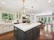 Bright, open kitchen with large island, farmhouse sink, modern lighting, and hardwood floors at 643 Baron Rd # 8, Waxhaw, NC 28173