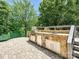 Beautiful outdoor kitchen with stone counter, stainless grill, refrigerator, cabinets, sink and view of lake at 643 Baron Rd # 8, Waxhaw, NC 28173