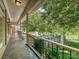 Spacious covered patio overlooking a lush yard and lake with stone flooring and black metal railing at 643 Baron Rd # 8, Waxhaw, NC 28173