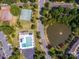 Aerial view featuring a pool, tennis courts, and a scenic pond in a green community at 6817 Dumbarton Dr, Charlotte, NC 28210