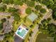 Aerial view of community with pool, tennis courts, and pond surrounded by lush greenery at 6817 Dumbarton Dr, Charlotte, NC 28210