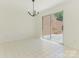 Bright dining area featuring tile floors, sliding glass doors, and a modern chandelier at 6817 Dumbarton Dr, Charlotte, NC 28210