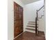 Entryway featuring a hardwood floor, staircase, dark door, and white walls at 6817 Dumbarton Dr, Charlotte, NC 28210