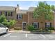 Charming brick townhouse with dark shutters, landscaping, and reserved parking spaces out front at 6817 Dumbarton Dr, Charlotte, NC 28210