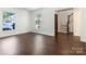 Inviting living room with hardwood floors, two windows letting in ample light, and staircase access at 6817 Dumbarton Dr, Charlotte, NC 28210