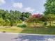 Picturesque pond with a fountain, landscaped shoreline, seating benches, and lush greenery at 6817 Dumbarton Dr, Charlotte, NC 28210