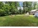 Lush backyard featuring a fire pit, rock garden, and a storage shed at 716 Mooresville Rd, Salisbury, NC 28144