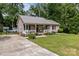 Charming home featuring a cozy front porch, lush lawn, and metal roof at 716 Mooresville Rd, Salisbury, NC 28144