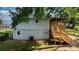Two-story home with a wooden deck, stairs, and walkout basement entrance surrounded by lush greenery at 73 20Th Sw Ave, Hickory, NC 28602
