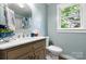 Stylish bathroom with beadboard walls, a marble vanity top, framed mirror, and wood flooring at 73 20Th Sw Ave, Hickory, NC 28602