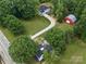 Aerial view of farmhouse with barn and long driveway amidst lush greenery at 828 N Main St, Mount Pleasant, NC 28124
