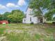 Well-maintained backyard featuring green grass, lush trees, and a rustic barn at 828 N Main St, Mount Pleasant, NC 28124