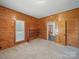 Charming bedroom featuring wood paneled walls, built-in shelves, and a neutral carpet at 828 N Main St, Mount Pleasant, NC 28124