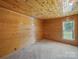 Bedroom with wood paneled walls, lots of natural light, and neutral carpet at 828 N Main St, Mount Pleasant, NC 28124