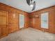 Bright bedroom with wood paneled walls and natural light from shuttered windows at 828 N Main St, Mount Pleasant, NC 28124