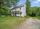 Charming two-story farmhouse with a covered front porch and lush greenery at 828 N Main St, Mount Pleasant, NC 28124