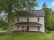 Charming two-story home with a metal roof, inviting porch, and mature trees in a serene setting at 828 N Main St, Mount Pleasant, NC 28124