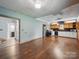 Open-concept kitchen features hardwood floors, black appliances, and wood and white cabinets at 828 N Main St, Mount Pleasant, NC 28124