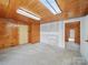 Cozy living room featuring knotty pine walls, carpet, and a skylight at 828 N Main St, Mount Pleasant, NC 28124