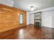 Cozy living room with hardwood floors, wood paneled walls, fireplace and natural light at 828 N Main St, Mount Pleasant, NC 28124