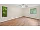 Bedroom featuring wood flooring, a ceiling fan, and large windows for natural light at 8338 Rittenhouse Cir, Charlotte, NC 28270
