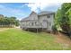 Large backyard with mature trees and grass, featuring a deck for outdoor enjoyment at 9004 Lauriston Pl, Mint Hill, NC 28227