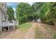 Backyard view features the deck, shed, mature trees, and grass at 9004 Lauriston Pl, Mint Hill, NC 28227