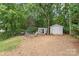 A spacious backyard featuring two storage sheds, fire pit, and wooded perimeter with grill at 9004 Lauriston Pl, Mint Hill, NC 28227
