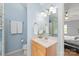 Light-filled bathroom features a wood vanity, blue walls, and access to the main bedroom at 9004 Lauriston Pl, Mint Hill, NC 28227