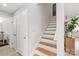 Hallway with wooden stairs, white walls, and multiple doors, offering a clean and inviting space at 9004 Lauriston Pl, Mint Hill, NC 28227