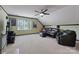 Bright bonus room features a leather couch, chair, ceiling fan, and window at 901 Brighton Dr, Kannapolis, NC 28081