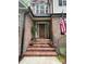 Inviting front porch with brick steps, decorative plants, and an American flag creating a warm welcome at 901 Brighton Dr, Kannapolis, NC 28081