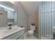 Cozy powder room showcasing a toilet, sink, mirror, and striped wallpaper at 901 Brighton Dr, Kannapolis, NC 28081