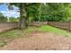 Large backyard with gravel section, fire pit, tree with bench and privacy fence at 910 W A St, Kannapolis, NC 28081