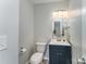 A quaint powder room featuring soft paint, a modern vanity, and an updated lighting fixture at 910 W A St, Kannapolis, NC 28081
