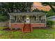 Charming single-story home featuring a welcoming front porch with decorative railings and manicured landscaping at 910 W A St, Kannapolis, NC 28081