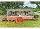Charming single-story home featuring a welcoming front porch with decorative railings and manicured landscaping at 910 W A St, Kannapolis, NC 28081