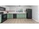 Well-lit kitchen with green lower cabinets, white upper cabinets, and modern appliances, plus sleek and stylish floors at 910 W A St, Kannapolis, NC 28081