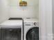 A functional laundry area featuring a newer washer and dryer, as well as a convenient storage shelf at 910 W A St, Kannapolis, NC 28081