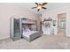 Large bedroom with a fan, bunk beds, and shelving, with a glimpse into the attached bathroom at 9125 Dylan Ridge Ct, Concord, NC 28027
