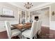 Dining area featuring a rustic wooden table, elegant seating, and views into other living spaces at 9125 Dylan Ridge Ct, Concord, NC 28027