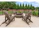 Backyard patio featuring a stone fire pit surrounded by comfortable Adirondack chairs at 9125 Dylan Ridge Ct, Concord, NC 28027