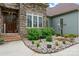 Inviting entryway featuring stone accents, decorative plants, and a solid wooden door at 9125 Dylan Ridge Ct, Concord, NC 28027
