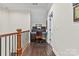 Hallway nook with a desk setup, hardwood floors, and natural light from the window at 9125 Dylan Ridge Ct, Concord, NC 28027