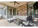 Relaxing outdoor patio area with stone fireplace and comfortable wicker seating with modern decor and a ceiling fan at 9125 Dylan Ridge Ct, Concord, NC 28027