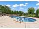 In-ground swimming pool surrounded by a concrete deck, aluminum fence, and manicured landscaping at 9125 Dylan Ridge Ct, Concord, NC 28027
